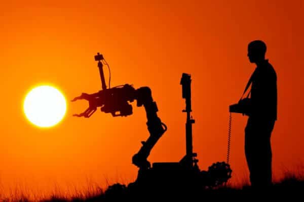 Man remote controlling robot at sunset