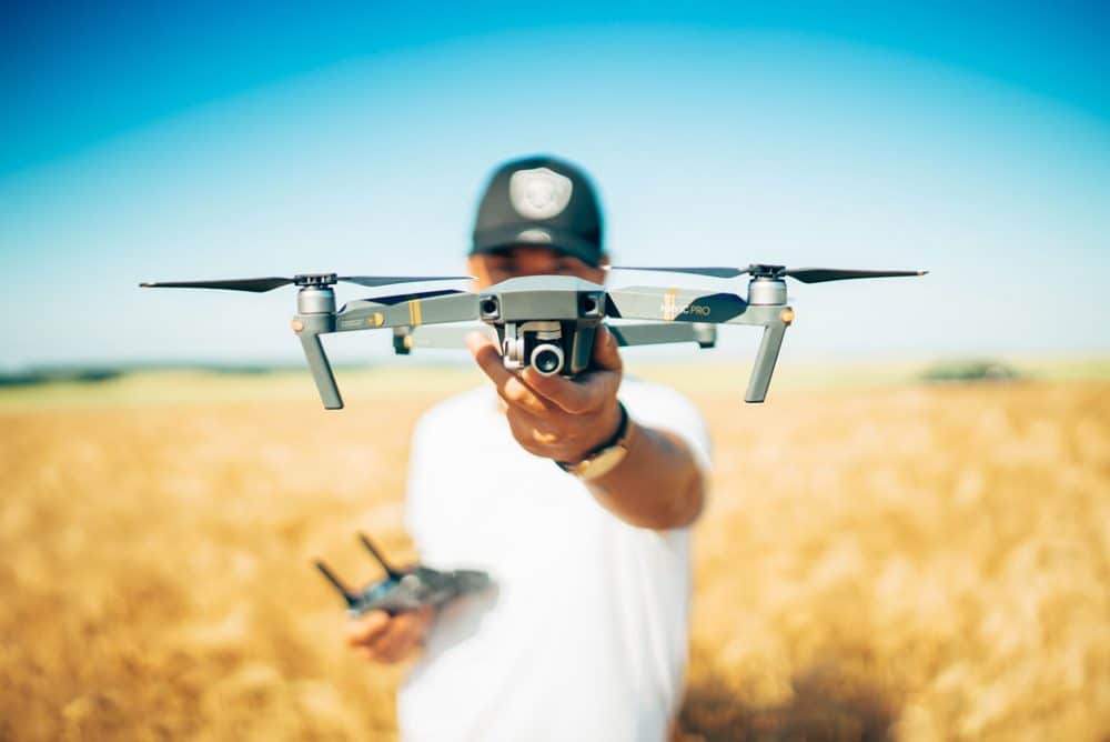 Man in wheat field holding drone